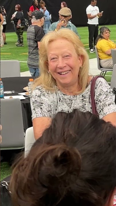 A guest smiling at a table during an outdoor event